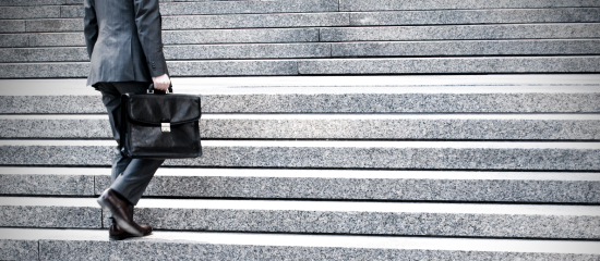 A man in a suit climbing some concrete stairs